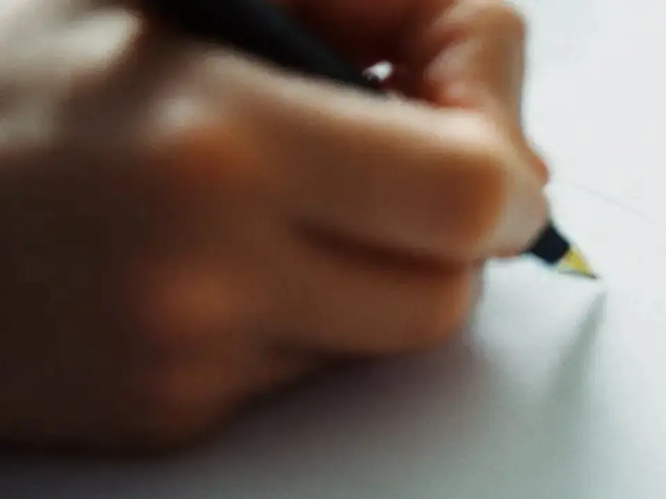 紙に住所を書き入れる手元